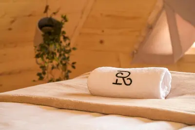 a towel sitting on top of a bed at Cottages Relax in Jajce