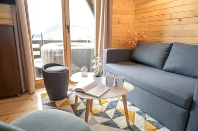 a living room with a blue couch and a table at Cottages Relax in Jajce