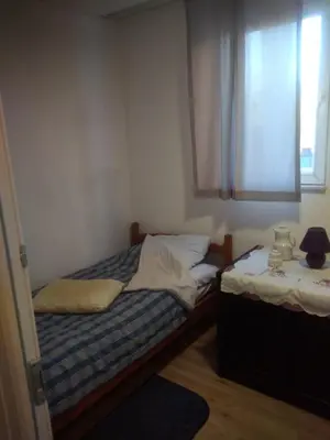 two twin beds in a room with a window at Hostel Mlinar in Bihać