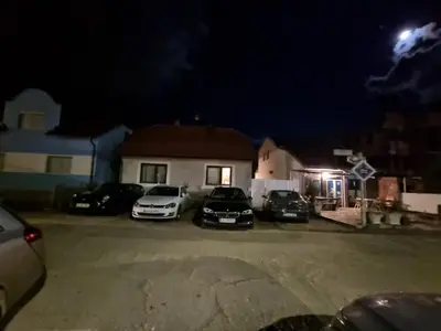 a group of cars parked in a parking lot at night at Hostel Mlinar in Bihać