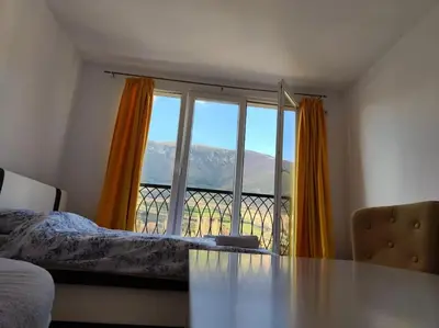 a room with a table and a large window at Apartman M&M in Travnik