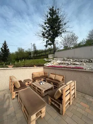 a patio with wooden furniture and a table and benches at Villa 46 - little heaven in Banja Luka