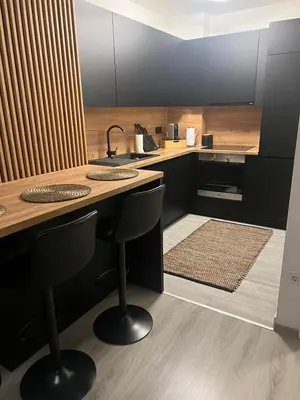 a kitchen with black cabinets and a wooden counter top at Una-No1 in Bihać
