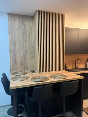 a wooden table with four chairs and a kitchen at Una-No1 in Bihać
