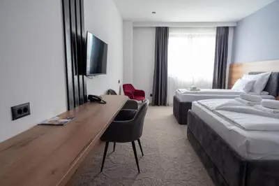 a hotel room with a desk and a bed at Hotel Sistems in Banja Luka