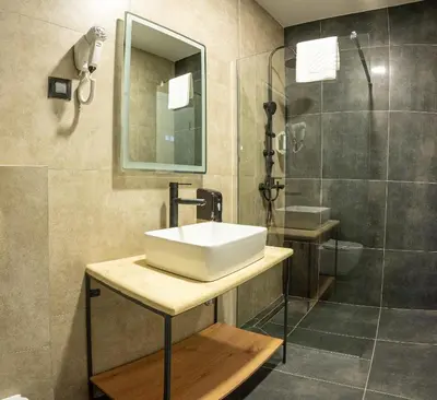 a bathroom with a sink and a shower at Hotel Sistems in Banja Luka