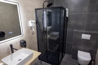 a bathroom with a shower and a toilet and a sink at Hotel Sistems in Banja Luka