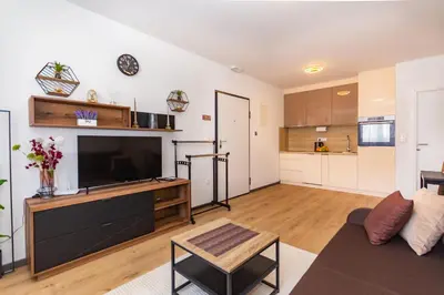 a living room with a television and a kitchen at Apartman Krželj A1 in Livno