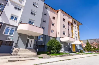 an apartment building with stairs in front of it at Apartman Krželj A1 in Livno