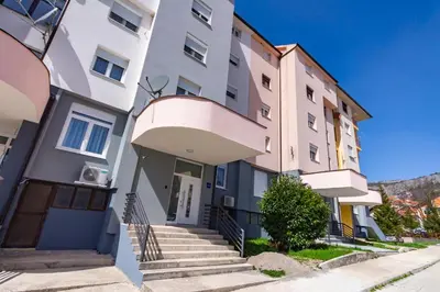 an apartment building with stairs in front of it at Apartman Krželj A2 in Livno