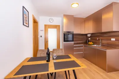 a kitchen with a table with a wine bottle on it at Apartman Krželj A2 in Livno