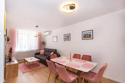 a living room with a table and chairs and a couch at Apartman Krželj A3 in Livno