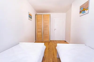 two beds in a room with a door at Apartman Krželj A3 in Livno