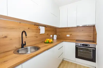 a kitchen with white cabinets and a sink at Apartman Krželj A3 in Livno
