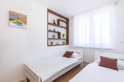 a bedroom with two beds and a window at Apartman Krželj A3 in Livno