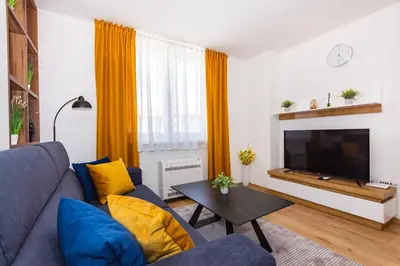 a living room with a blue couch and a tv at Apartman Krželj A4 in Livno