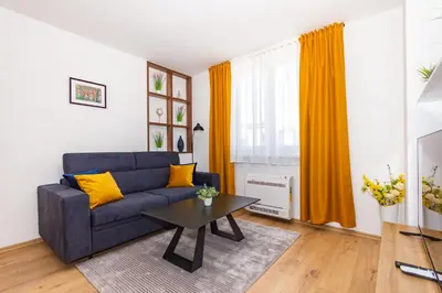 a living room with a blue couch and a table at Apartman Krželj A4 in Livno