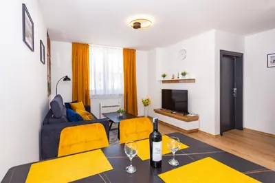 a living room with a blue couch and yellow chairs at Apartman Krželj A4 in Livno