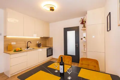 a kitchen with a table with a bottle of wine at Apartman Krželj A4 in Livno