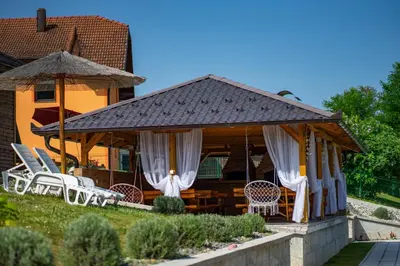 a house with a gazebo with chairs and tables at Una Relax in Bosanski Novi