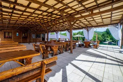 a pavilion with wooden tables and wooden benches at Una Relax in Bosanski Novi