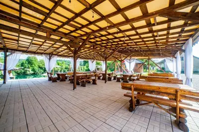 a large pavilion with wooden benches and tables at Una Relax in Bosanski Novi