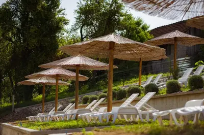 a group of white chairs and umbrellas at Una Relax in Bosanski Novi