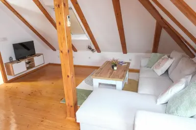 a living room with a white couch and a table at Apartman Maja in Jajce