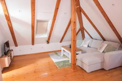 a living room with a white couch in a attic at Apartman Maja in Jajce
