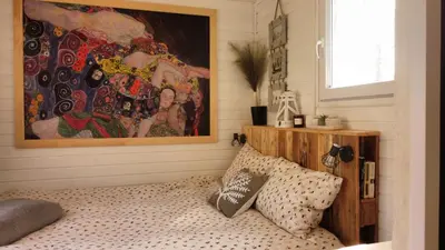 a bedroom with a bed and a painting on the wall at Sole Tiny House in Šipovo