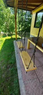 a porch swing with a bench in front of a house at Sole Tiny House in Šipovo
