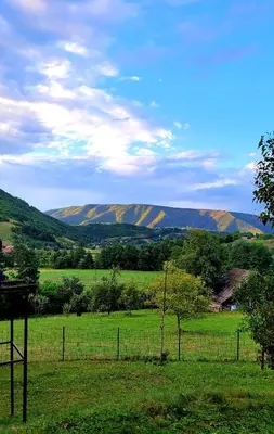 a fence in a field with a mountain in the background at Sole Tiny House in Šipovo