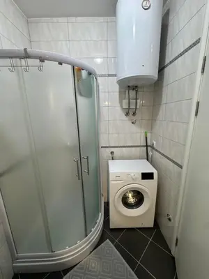a small bathroom with a toilet and a washing machine at Apartman 50 in Banja Luka