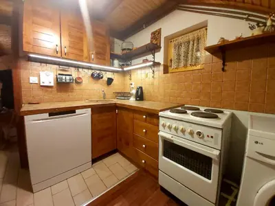 a kitchen with a white stove and wooden cabinets at Holiday Home Tirol in Vlasic