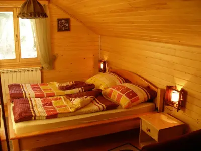 a bedroom with two beds in a log cabin at Holiday Home Tirol in Vlasic
