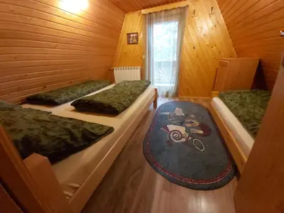 two beds in a wooden cabin with a window at Holiday Home Tirol in Vlasic