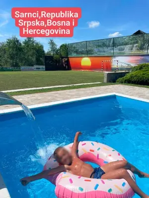 a child laying on an inflatable swim ring in a swimming pool at Villa Mia in Prnjavor