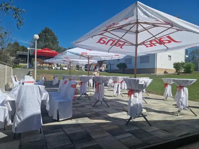a group of tables and chairs under an umbrella at Villa Mia in Prnjavor