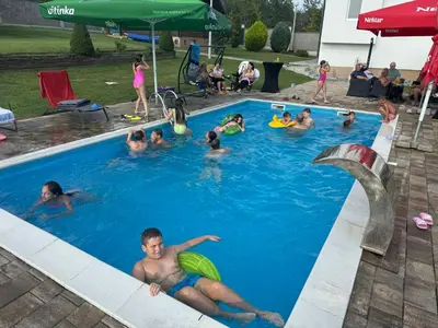 a group of people swimming in a swimming pool at Villa Mia in Prnjavor