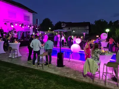 a group of people at a party by a pool at night at Villa Mia in Prnjavor
