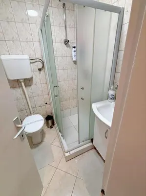 a bathroom with a shower and a toilet and a sink at Stan na dan CentarM in Banja Luka