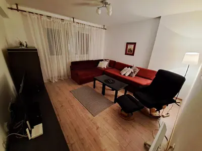 a living room with a red couch and a table at Stan na dan CentarM in Banja Luka