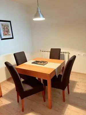 a dining room table with black chairs and a light at Stan na dan CentarM in Banja Luka