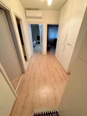 a hallway of an apartment with a wooden floor at Stan na dan CentarM in Banja Luka