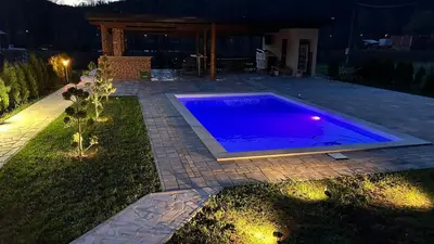 a swimming pool in a backyard at night at Villa LANA Krupa na Vrbasu in Banja Luka