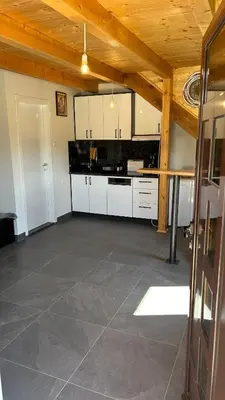 a large kitchen with white cabinets and a wooden ceiling at Villa LANA Krupa na Vrbasu in Banja Luka