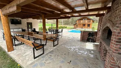 an outdoor patio with a table and a fireplace at Villa LANA Krupa na Vrbasu in Banja Luka