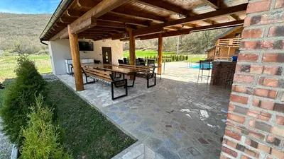 an outdoor patio with a table and a grill at Villa LANA Krupa na Vrbasu in Banja Luka