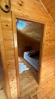 a small room with a bed in a wooden cabin at Villa LANA Krupa na Vrbasu in Banja Luka
