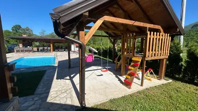 a playground with a swing and a pool at Villa LANA Krupa na Vrbasu in Banja Luka